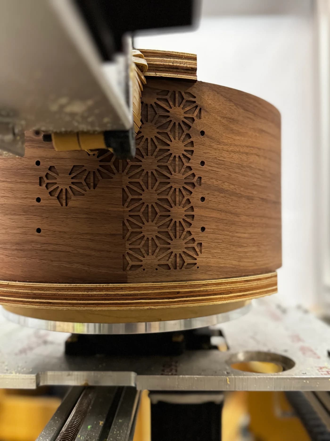 An Asanoha drum shell being machined on DrumBot, with the cutting head close to the patterned wood shell.